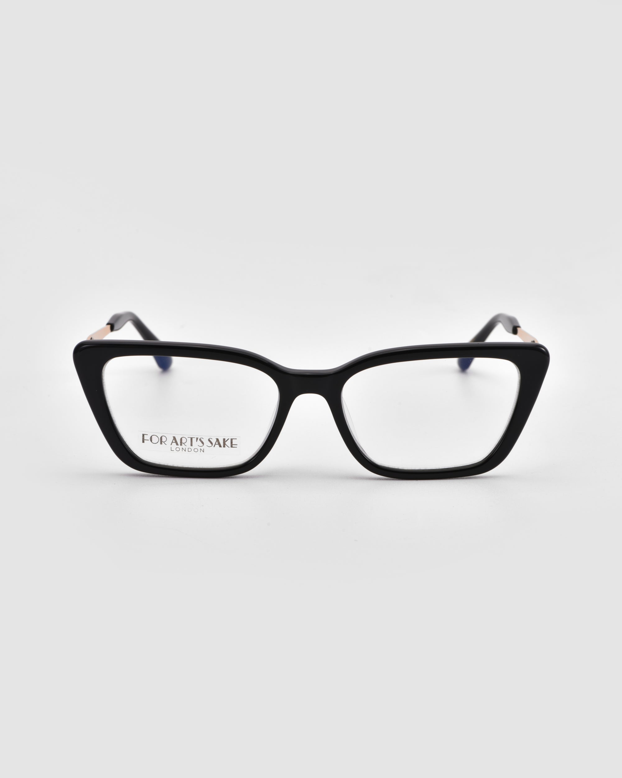A pair of black cat-eye Harmony(X) eyeglasses by For Art's Sake®, featuring sculptural temples and clear lenses, is displayed on a light gray background. “FOR ART’S SAKE LONDON” appears on the inner side of one lens.