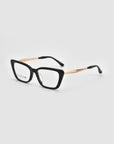 Harmony(X) eyeglasses by For Art's Sake® feature black square frames and sculptural gold metal temples, shown on a light gray background.
