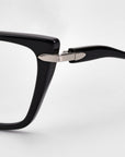 Close-up of For Art's Sake® Motion I eyeglasses, highlighting the black frame, hinge, and acetate temples with a sleek metal accent, set against a plain light background.