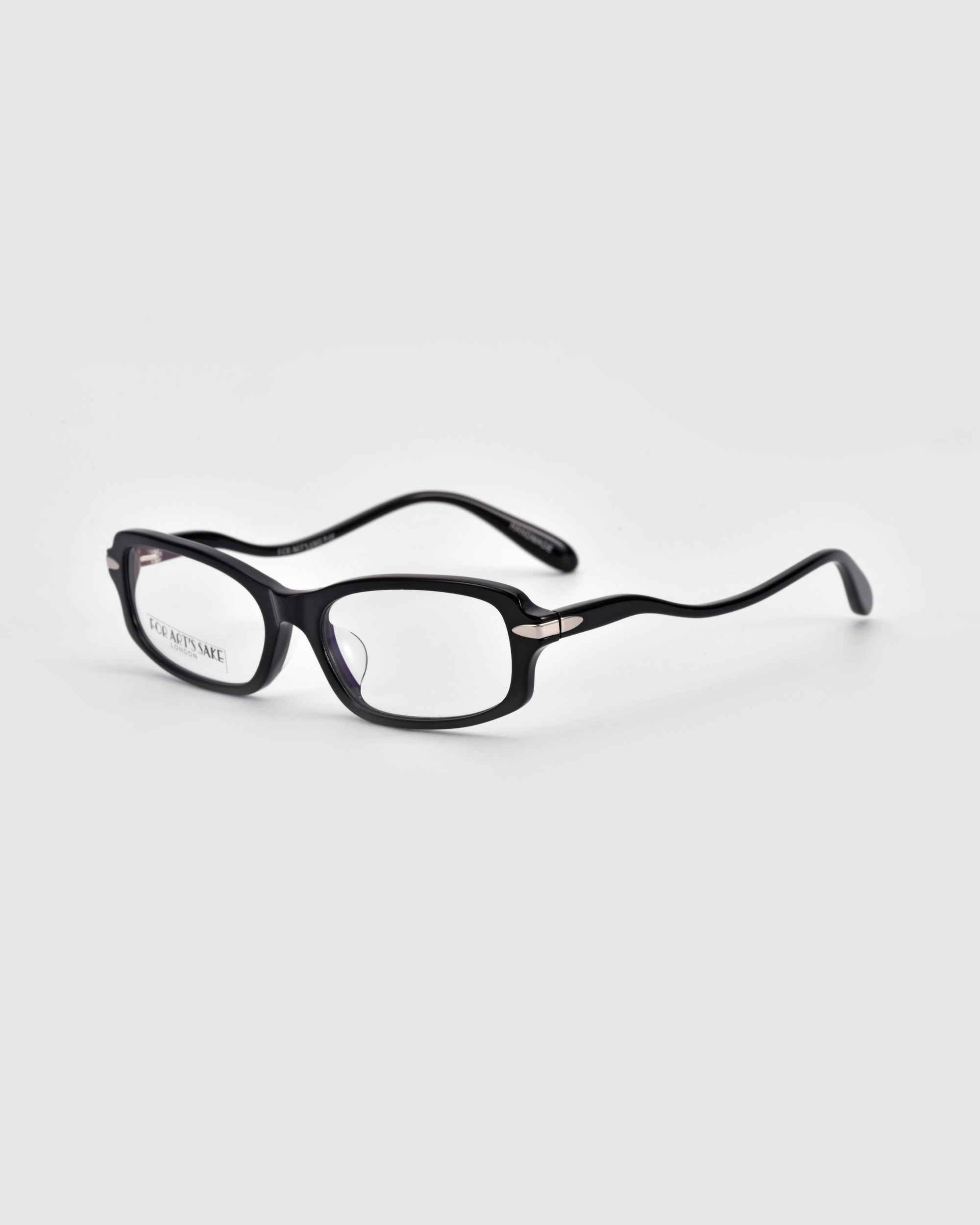 The Motion II sunglasses by For Art's Sake® are black, boxy, and rectangular with curved acetate temples and subtle metal hinge accents, displayed on a plain light gray background.