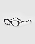 The Motion II sunglasses by For Art's Sake® are black, boxy, and rectangular with curved acetate temples and subtle metal hinge accents, displayed on a plain light gray background.