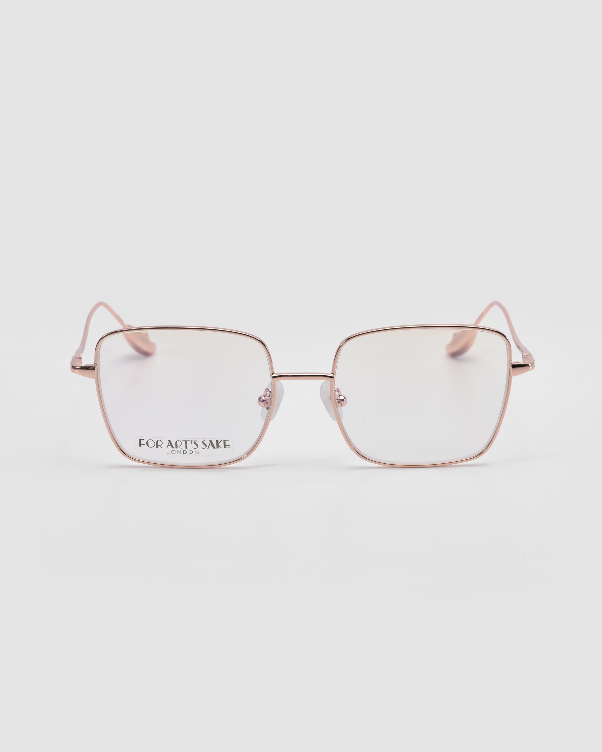 The For Art's Sake® Garden is a pair of modern squared metal glasses with thin gold frames and clear lenses, offering lightweight comfort, displayed on a plain white background.