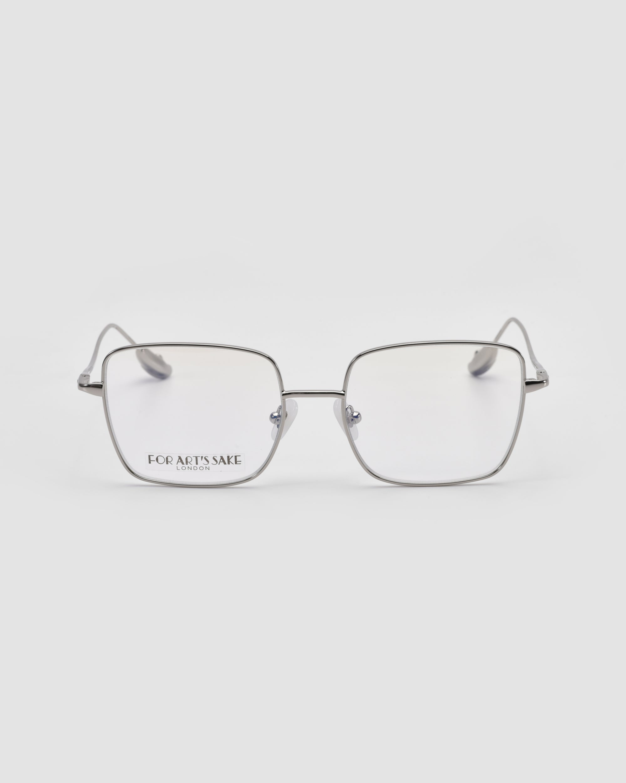 A pair of modern squared metal glasses named "Garden" by For Art's Sake®, featuring thin silver frames, clear lenses, and subtle branding on the left lens—distinctive eyewear displayed on a white background.