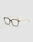 The Claudia green square eyeglasses by For Art's Sake® feature clear lenses and distinctive gold wavy sculpted temples, shown on a light gray background.