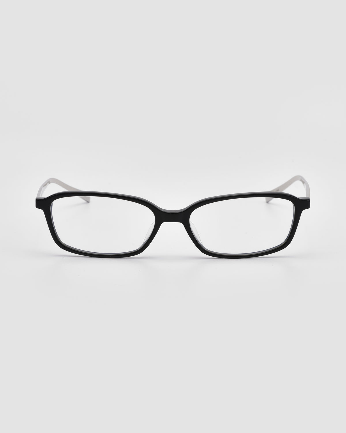 The Lumi I by For Art’s Sake®—black rectangular optical frames with clear lenses and sleek metal temples—are centered on a plain white background.