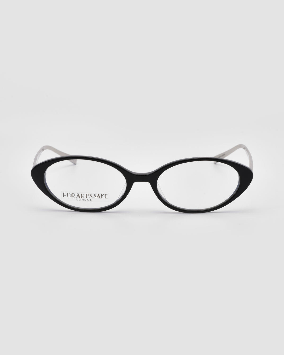 Lumi II by For Art’s Sake®: Black cat-eye optical frames in premium acetate with clear lenses. “FOR ART’S SAKE LONDON” is printed on the left lens against a plain white background.