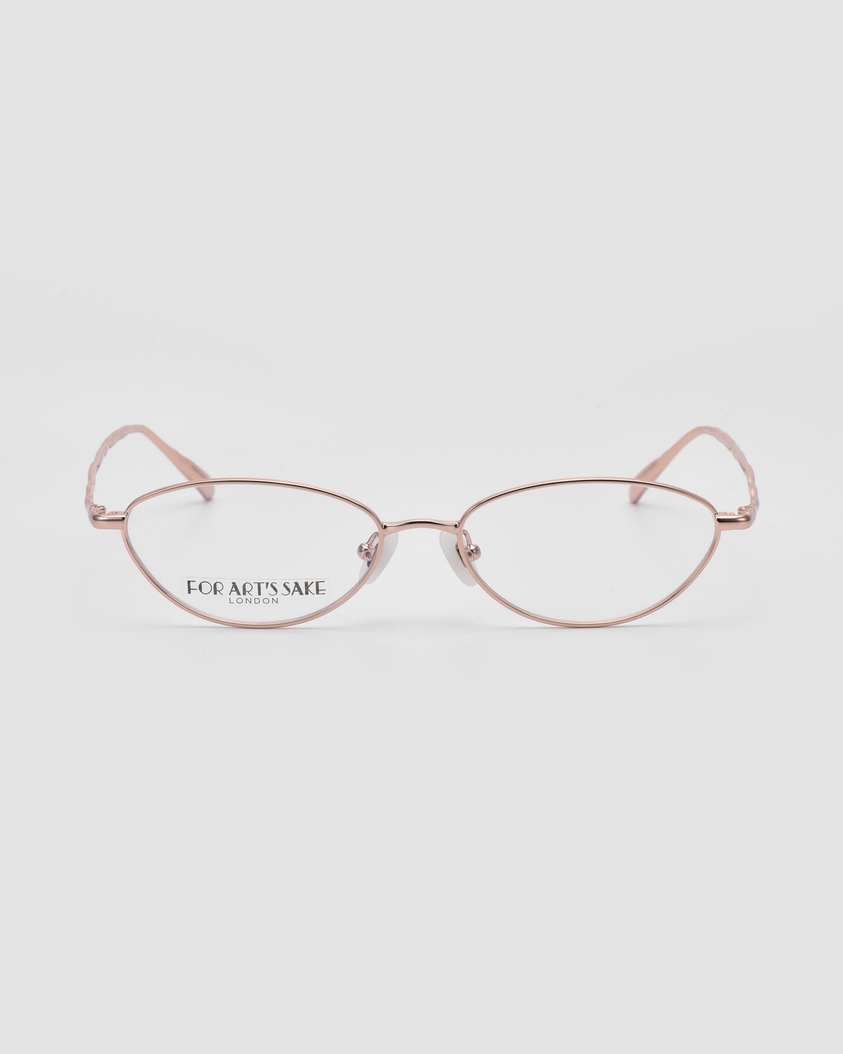 Suree II by For Art’s Sake®: Delicate pink metal cat-eye optical frames with thin metal rims, clear lenses, and “For Art’s Sake®” branding on the left lens, shown against a white background.