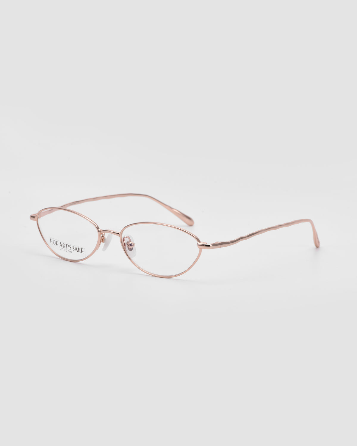 Suree II by For Art’s Sake®: Rose gold oval silhouette optical frames with thin metal and clear lenses, shown on white. “EYE ARTISANACE” text logo appears on the left lens.