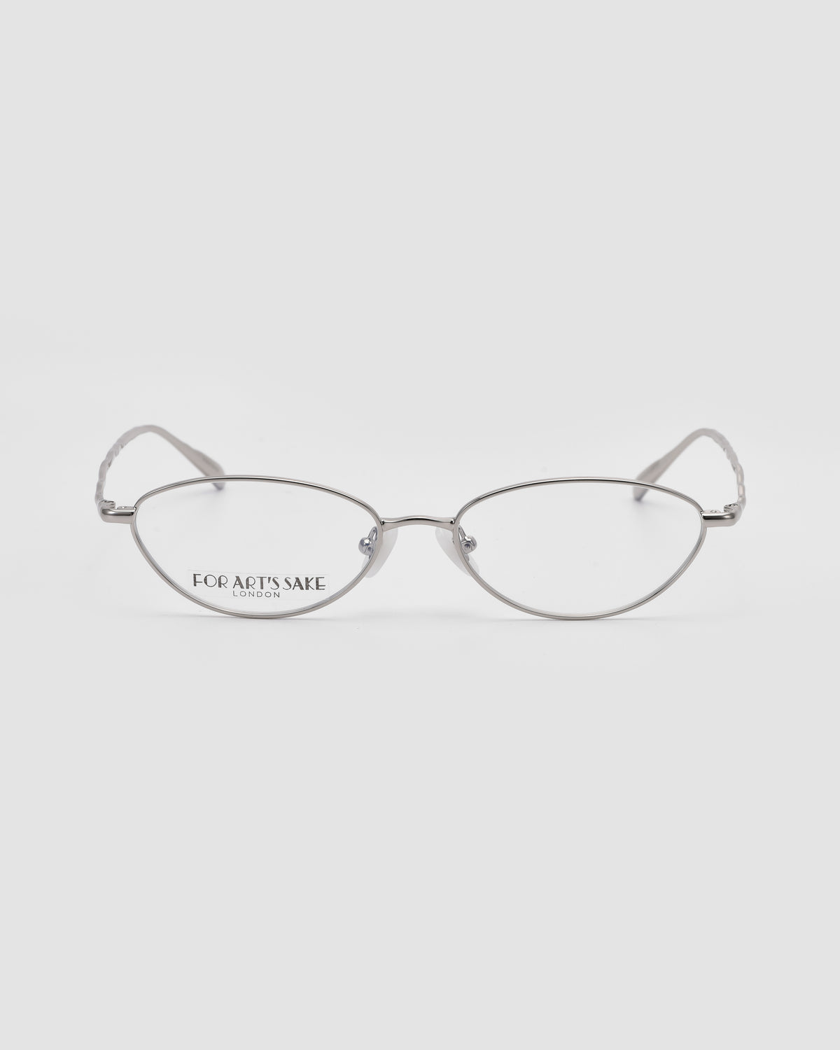Suree II silver oval eyeglasses by For Art’s Sake® feature thin metal frames and an elegant oval silhouette, shown on a white background with the brand “For Art’s Sake London” in black on the left lens.