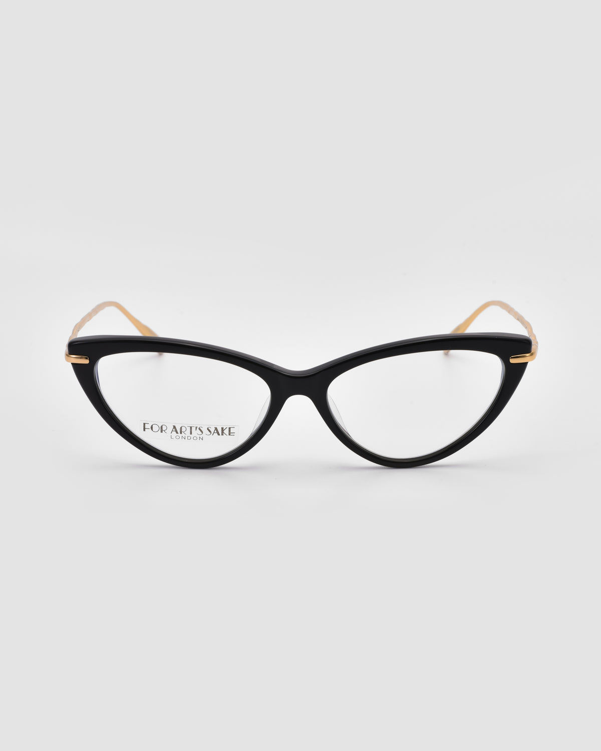 Solange by For Art’s Sake®: Black cat-eye opticals with clear lenses, sculpted metal temples, and gold accents on the arms, shown on a plain light gray background.