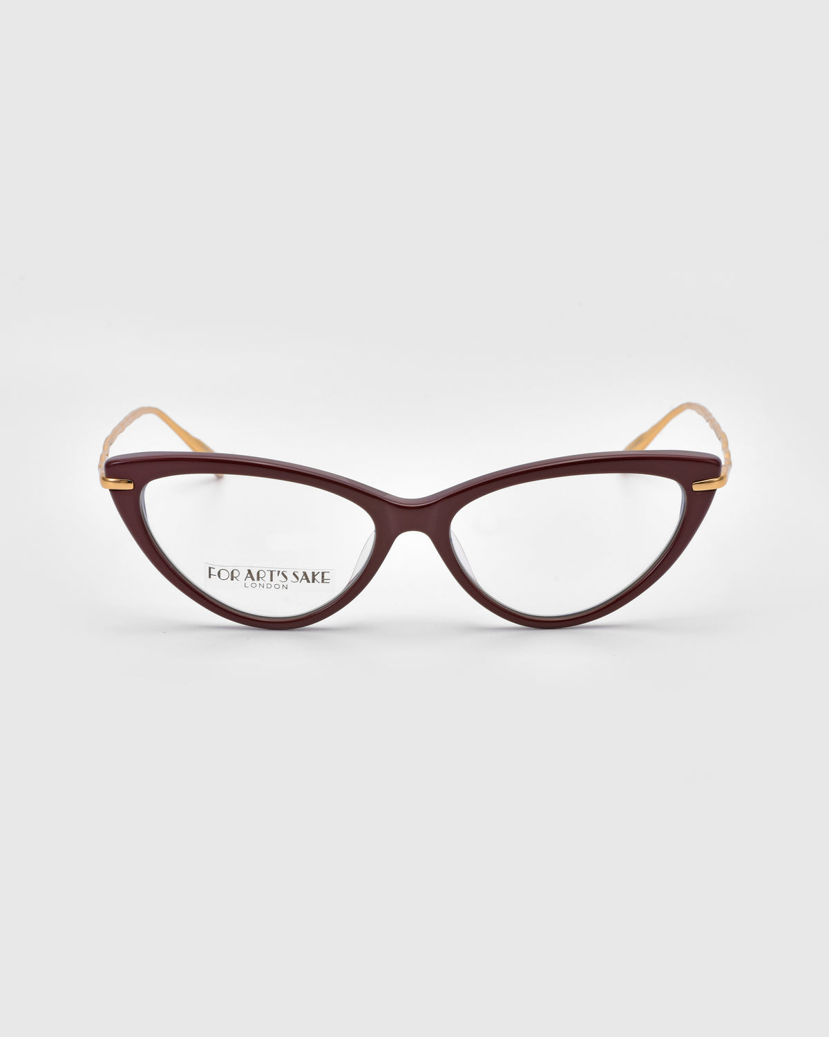Solange by For Art’s Sake®: cat-eye opticals with dark red frames, clear lenses, sculpted metal temples, and a “FOR ART’S SAKE” logo on the left lens, shown on a light gray background.