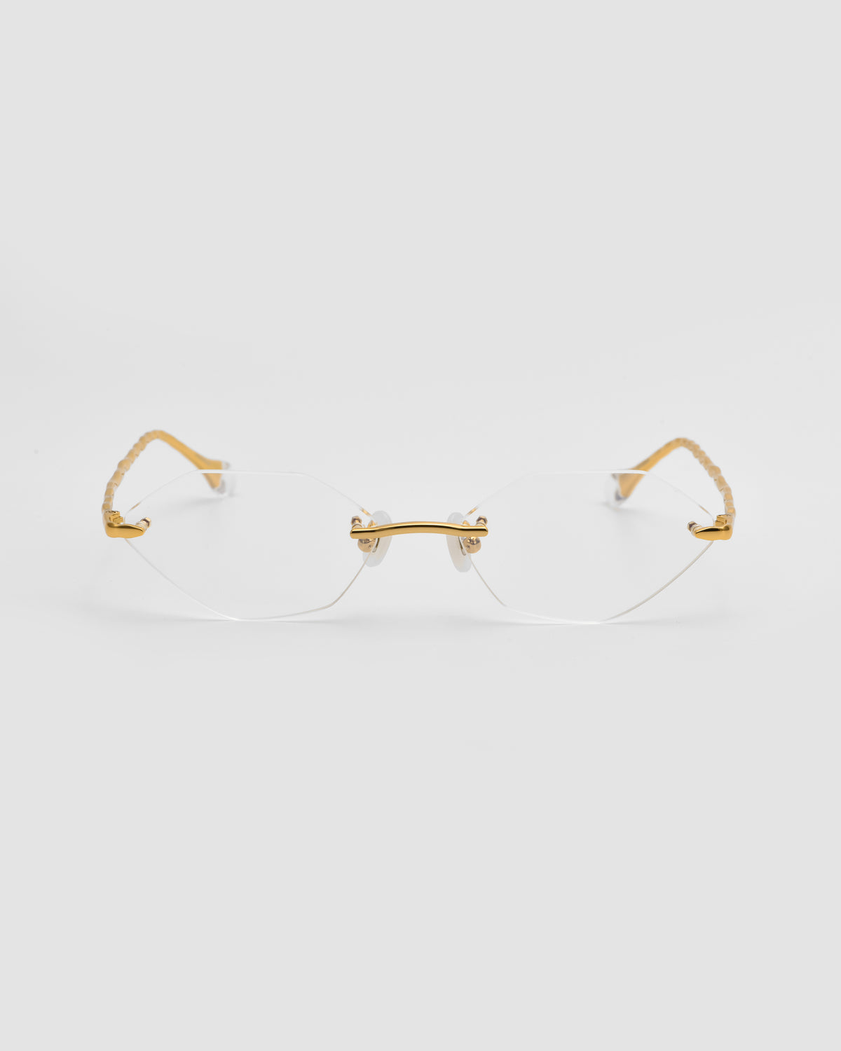 Amara I by For Art’s Sake® rimless eyeglasses with gold temples and bridge, plus sculpted nylon temple tips, displayed front view on a white background.
