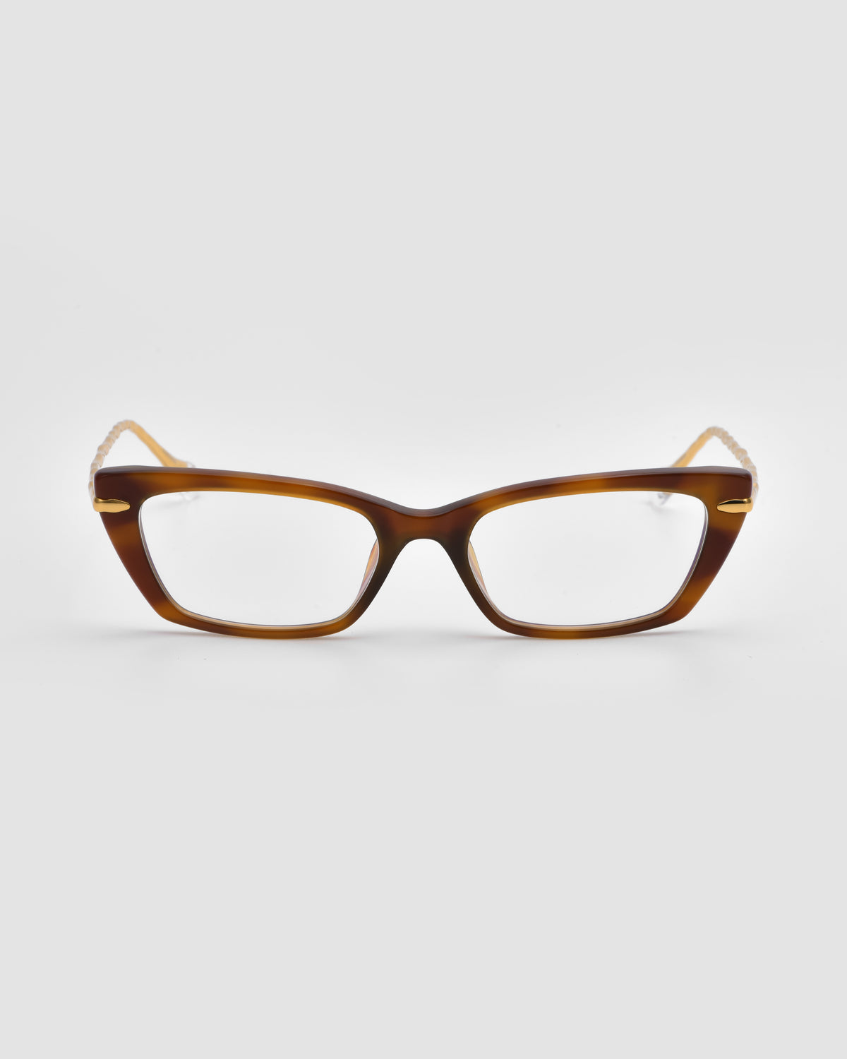 The Amara II by For Art’s Sake® is a brown rectangular optical frame with thick, jewel-inspired translucent fronts, a slight cat-eye shape, and sculpted nylon temple tips for comfort. Shown from the front.