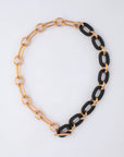 The For Art's Sake® Bexley Necklace showcases chunky resin with alternating large gold and black 18-karat gold-plated links, finished with a toggle clasp and displayed on a plain white background.