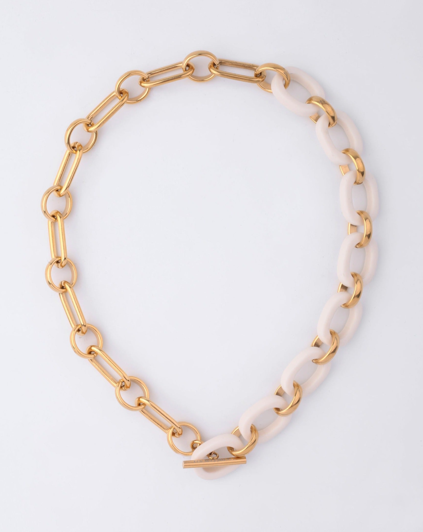 The Bexley Necklace by For Art's Sake® showcases chunky resin links with alternating large gold and ivory ovals, finished in radiant 18-karat gold plating and secured with a toggle clasp, shown on a plain white background.
